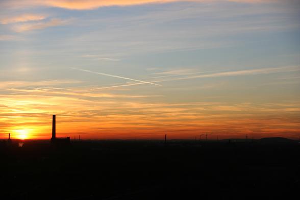 Ein Foto. Die untergehende von einem ausgebrannten Hochofen aus, im Landschaftspark-nord in Duisburg