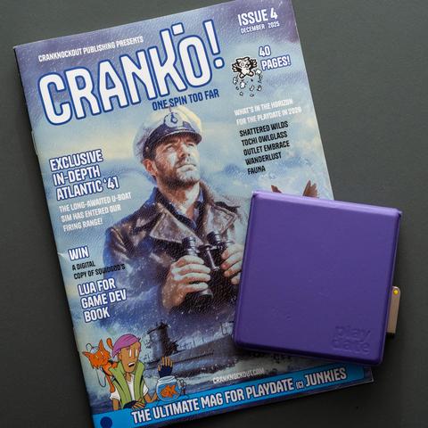 the cover of «Cranko!» showing a U-Boat captain; there is a PlayDate handheld with a purple cover on top of the zine