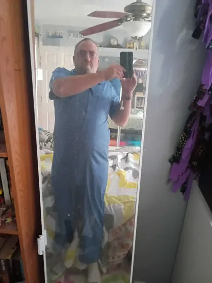 Picture of the user in front of a mirror wearing a light blue jumpsuit/coveralls