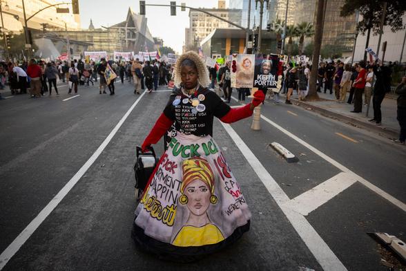 Eine Frau hält während einer Demonstration in Los Angeles am 10. Januar Bilder von Renee Nicole Good und Keith Porter in den Händen. Foto: Étienne Laurent