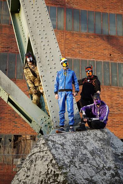 HeRO, Taiyo, Danzo and Aki on the foundation of a massive metal ore excavation lift. Taken before XGear Winter Edition 2026