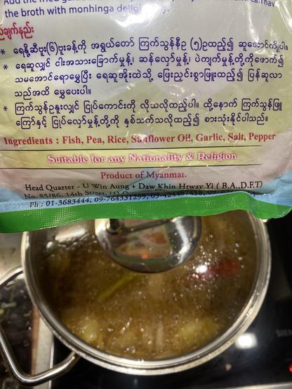 Mohinga cooking in a pot with the lid closed. Package information in Myanma with English explanation: „suitable for any nationality and religion”