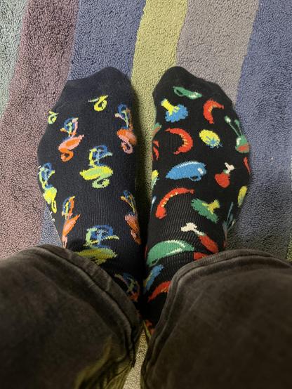 Zwei verschiedene Socken, beide schwarze grundfarbe und dann bunte Verzierungen