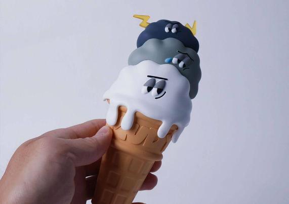 A hand holds a colorful ice cream cone with three scoops, each displaying unique, playful expressions and a drippy texture.