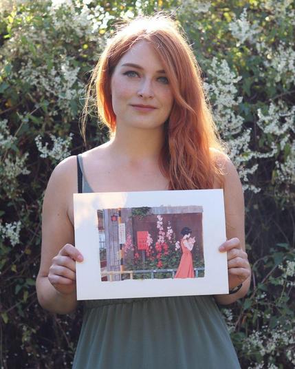 artist holding original artwork