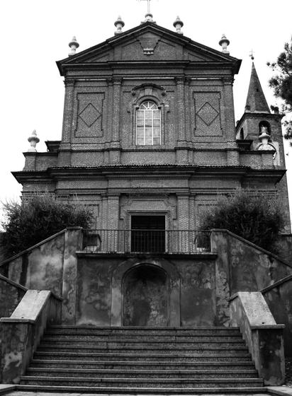 Foto in bianco e nero della facciata  settecentesca di una chiesa, in particolare si tratta della chiesa di S. Nicola Vescovo di Alice Castello, in Piemonte.
