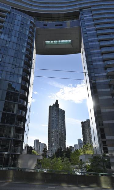 A much more modestly-sized tower mostly clad in glass… …but it's more of an arch shape than a monolith. You can see the sky and another skyscraper through the "arch" of the tower.