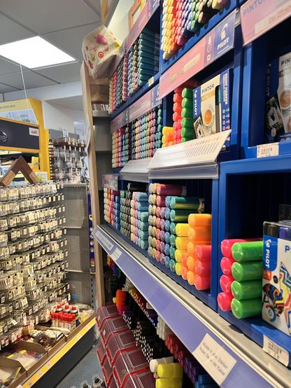 Foto eines Regals voll mit Acrylmarkern in allen erdenklichen Farben. Im Hintergrund sieht man weitere Regale bestückt mit kleinteilen.