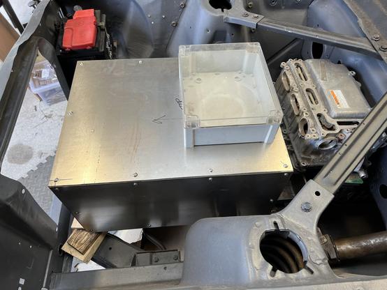 Side view of metal box sitting in engine bay.