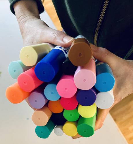 Foto davon wie ich 24 dicke Acrylmarker in beiden Händen halte wie einen Blumenstrauß