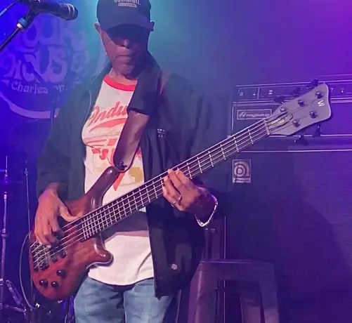 Photo of Billy Bass Nelson, playing a Warwick 5-string bass in front of an Ampeg amp