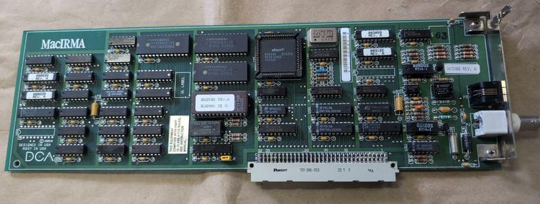 A long NuBus card with two external connectors, one of which is co-ax. The board is heavily populated and has MacIRMA screenprinted in the corner. DCA is printed in large letters in another corner.