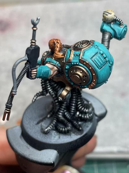 A Warhammer model. It’s a tech-priest with metal tentacles instead of legs, a big crushing hand, and a scanner.