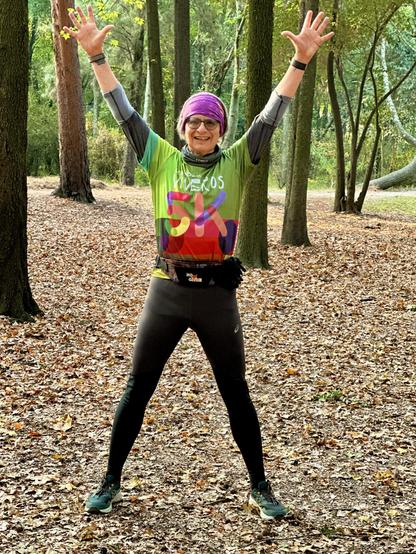 A happy runner surrounded by trees.
