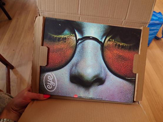 A photo of Matt Holding a magazine in a cardboard sleeve. You can see the front cover which features a close up photograph of a nose and some sunglasses with the eye logo in the corner.