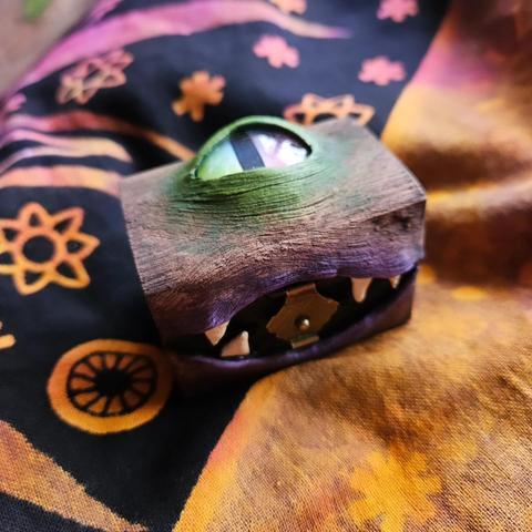 A small wooden box with one big eye and some small teeth