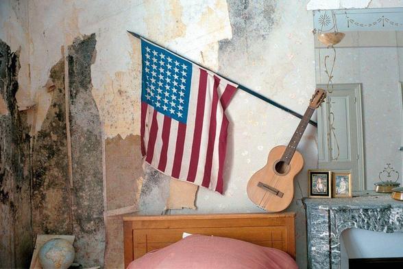photo of single bed with usa flag and instrument on headboard