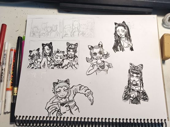 photograph of a sketchbook with drawing tools beside it. there are a couple thumbnail sketches along with character drawings made to finalize a composition. all the characters are mean girls wearing cat ears