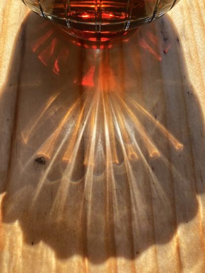 Light reflected in a glass of coke to create the illusion of a camino shell