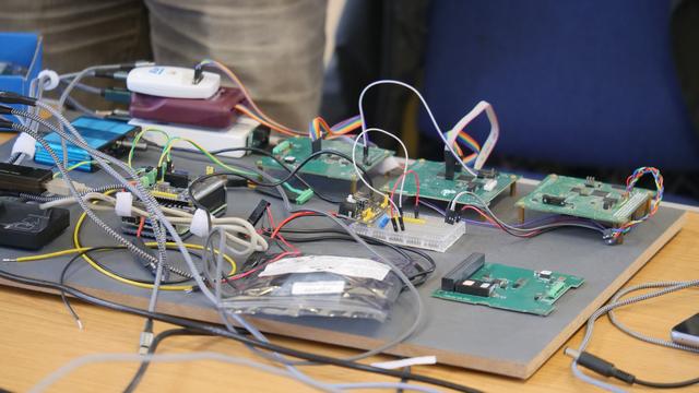 A bread board with several PCBs on a table with loads of wires interconnecting prototype boards.