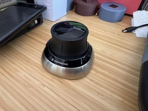 a photo of the 3DConnexion wireless SpaceMouse on a bamboo desk