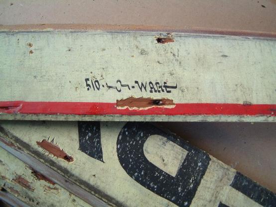 Detail of weathered boards with hand-painted lettering on them. The upper most board has a small signature, "Ware", following the number 510 and a trade union insignia.