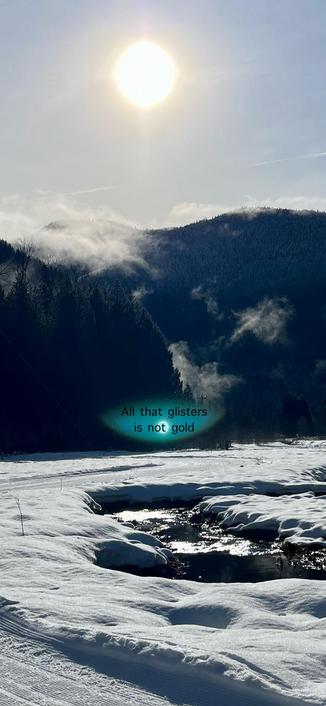 A snow covered field with a sparkling stream under a bright sky, golden sun above. 
A dark-treed hill in the distance with a few wispy clouds. A text box hovers over the stream with Shakespeare’s quote: All that glisters is not gold.