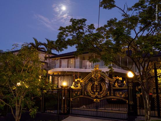 An extraordinarily elaborate and rococo front gate on an otherwise simply-architected suburban house. Except for scale, they wouldn't be out of place on a palace.