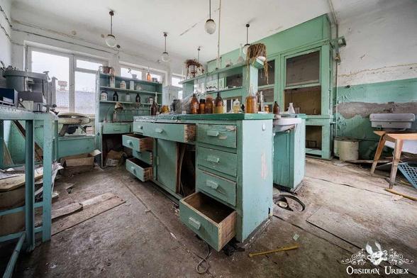 abandoned old lab, with blue wooden counters and fume cupboards