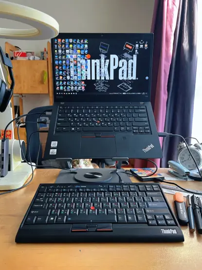 A ThinkPad T490 connected to a T420/X220 keyboard USB kit made by H-Studio. The keyboard is the Taiwan/Hong Kong/Macau layout, and there is a Devon Rex cat behind the laptop and its stand.