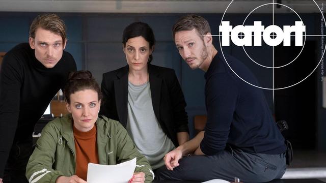 Tatort Saarbrücken: Kommissare Schürk, Hienrich, Baumann und Hölzer versammelt um einen Schreibtisch, auf dem Papiere und Büromaterial liegen. (Foto: dpa Bildfunk, picture alliance/dpa/ARD/SR | Manuela Meyer)