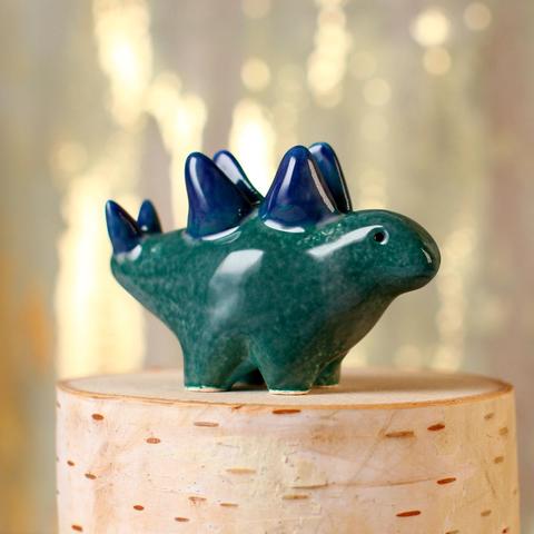 A small dark teal ceramic stegosaurus with a light blue belly and navy plates and thagomizer.