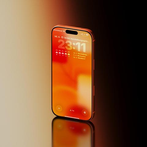 An orange iPhone 17 Pro standing on a reflective surface, displaying the time on a fiery-toned background.