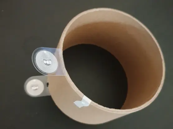 Tube en carton qui se trouvait dans le support en plastique. On peut voir la languette avec ses puces rfid et le bout d'adhésif qui maintenait l'extrémité du filament.