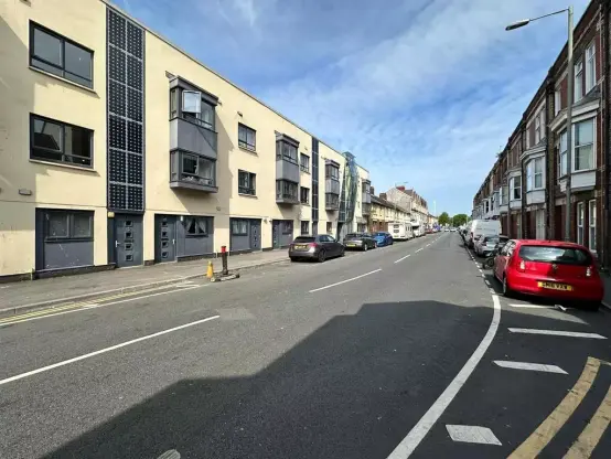 View along Station Road in Llanelli towards the town centre, showing residential buildings and parked cars.