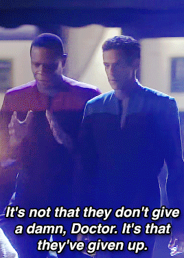 (first gif in a gifset) julian bashir and benjamin sisko, from star trek deep space 9, talking while they walk in a dirty street filled with tents, fire and smoke. benjamin sisko is a black man with very short black hair, using a black and red uniform. julian bashir is thin, brown man with medium short black hair, using the same uniform, but in a black and blue version.

benjamin says (visible in the subtitles): it's not that they don't give a damn, doctor. it's that they've given up.