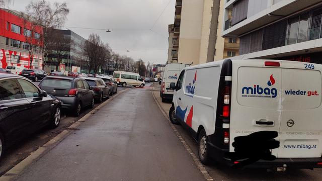 Zwei Lieferwagen stehen auf dem Gehweg.