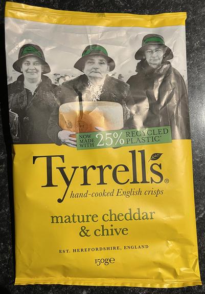 Tyrrell’s crisp packet of mature cheddar & chive flavour crisps, with a banner stating “now made with 25% recycled plastic” but it’s not clear if the mean the crisps or the packaging