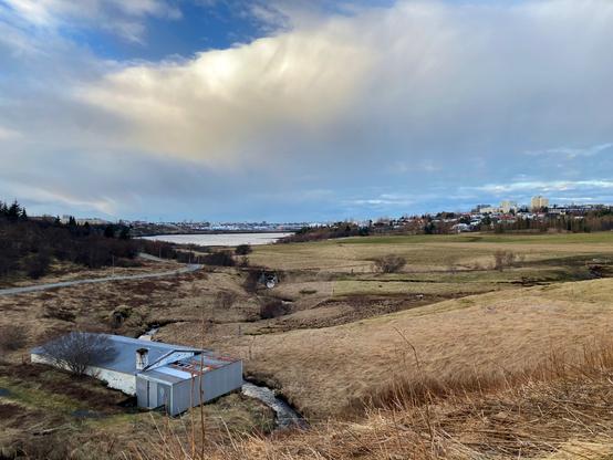 An abandoned hatchery next to a river surrounded by fields.