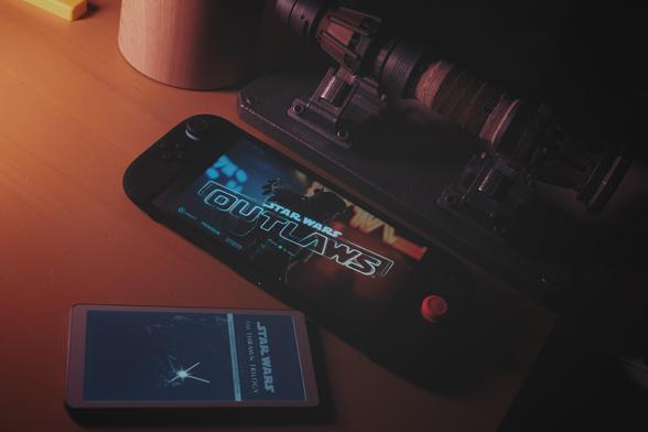 Rey’s lightsaber hilt. Star Wats Outlaws running on Nintendo Switch 2. Star Wars Thrawn trilogy on a ViWoods ereader.