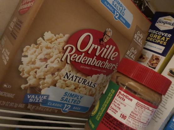 Box of microwave popcorn branded "Overille Redenbacher's Naturals".