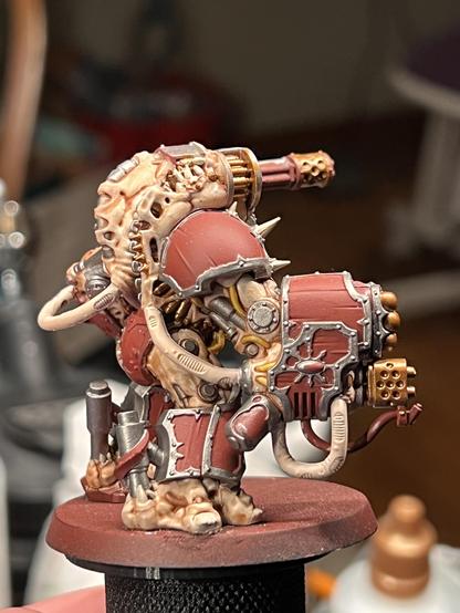 A work in progress paint job of a Chaos Space Marines Obliterator from Warhammer 40K. This side view allows a better look at many of the details worked on tonight, such as the ammo feed for his shoulder chain gun or the teeth erupting from said ammo belt.