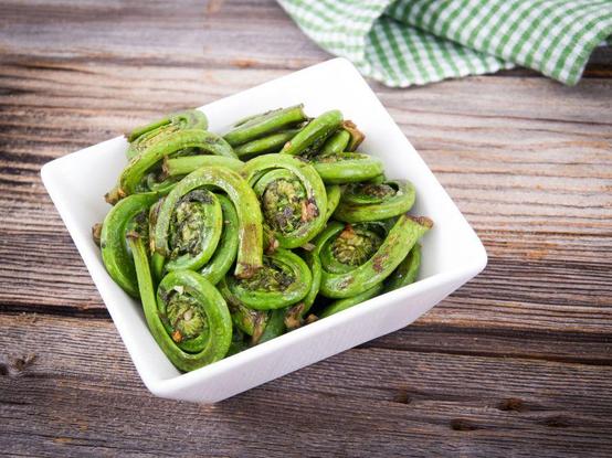 White dish filled with cooked fern heads