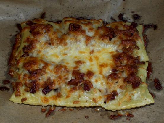 The cheese topped dumplings after baking. The cheese is melted and has a golden bown crust.