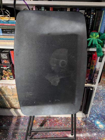 A small folding table covered in paint and glue stains.