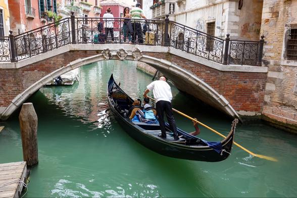 A gondola passing under one of the innumerable bridges in Venice