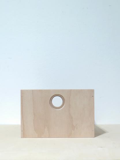 front view of a recently built prototype of a 7inch record box. the box is made of 8mm birch plywood with a 3mm hdf plate bottom. two sides of the box are perforated with a circular hole to carry it. the box is made with glued and nailed butt joints. the bottom is floating inside a milling groove.