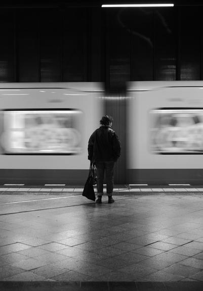 picture of someone waiting for a train with the train in motion blur