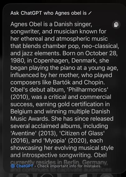 The image shows a phone screen displaying a text block about Agnes Obel, a Danish singer, songwriter, and musician known for her ethereal music blending chamber pop, neo-classical, and jazz elements. The text details her birth in Copenhagen in 1980, early piano influences, and career highlights including her debut album *Philharmonics* (2010) and subsequent releases *Aventine* (2013), *Citizen of Glass* (2016), and *Myopia* (2020). The interface includes a small ChatGPT logo at the bottom with a note to “Check important info for mistakes.” This alt-text was autogenerated using Apple Intelligence Private Cloud Compute.