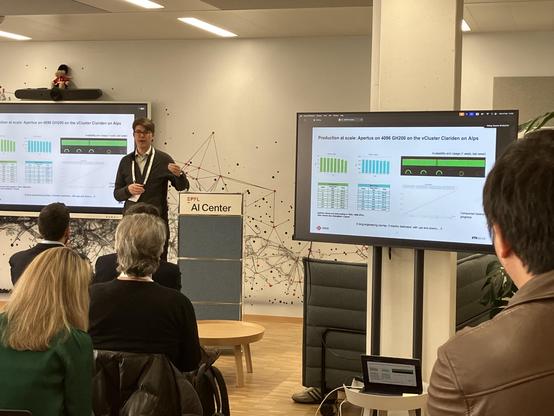 A speaker presenting the infrastructure for training LLMs. On screen:
Production at scale: Apertus on 4096 GH200 on the Cluster Clariden on Alps
Avalabilty and Usage engineering joumey, 3 months decicated, with ups and downs.
ETH zurich